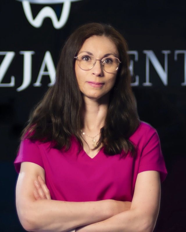 Agnieszka Roszczyk w portrecie na tle oszklenia z sygnaturą kliniki