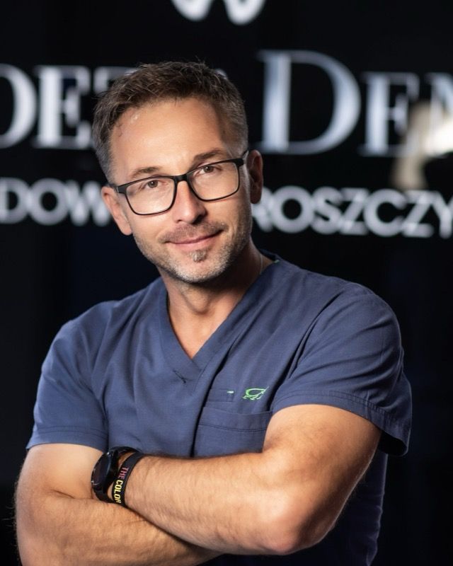 Arkadiusz Sadowski w portrecie na tle oszklenia z sygnaturą kliniki